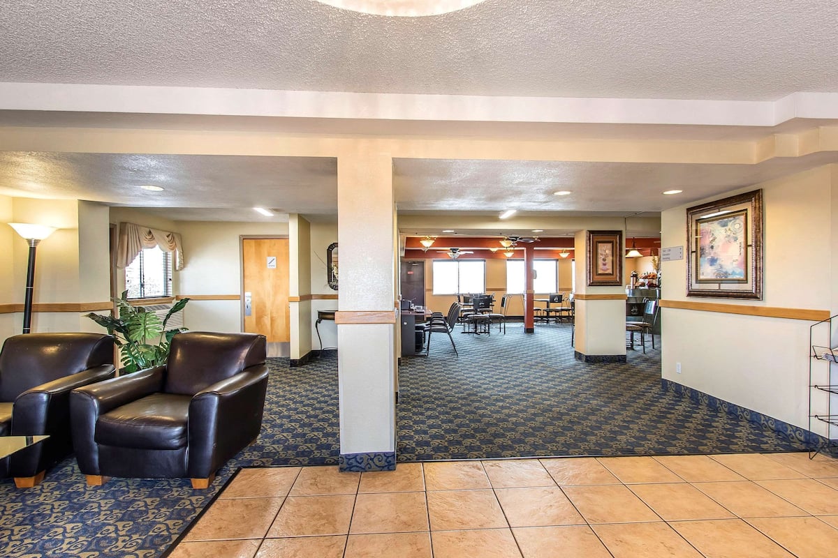 A lobby with a reception desk, seating area, and a patterned carpet.