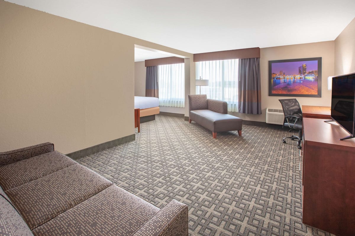Een hotelkamer met een bed, een bank, een bureau en een televisie.