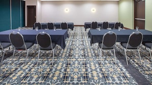 A conference room with six tables, each with chairs and glassware, carpeted with a floral pattern. - Baymont Inn & Suites Grand Rapids Near Downtown (Grand Rapids)