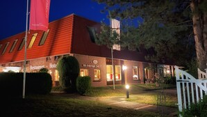 Rakennuksessa on punainen katto ja kyltti, jossa lukee: ”Ravintola – Hotelli”.