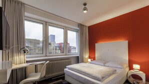 A modern hotel room with a large bed, a desk, and a chair. - Cityhotel Monopol (Hamburg)