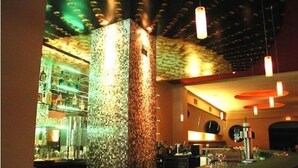 A bar area with a textured column, pendant lighting, and a modern interior design. - Cityhotel Monopol (Hamburg)