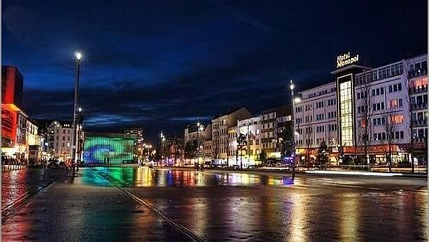 A nighttime cityscape with a prominent hotel named "Hotel Monopol" on the right. - Cityhotel Monopol (Hamburg)