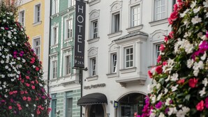 Un hôtel avec une enseigne indiquant « HÔTEL FORSTINGER » et un panneau indiquant un parking ouvert 24 heures sur 24.