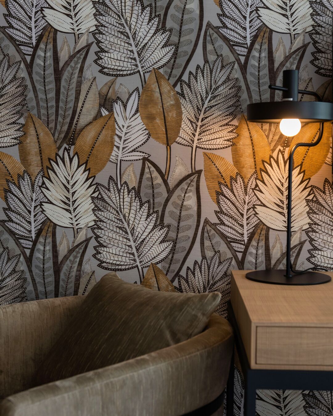 A room with a patterned wallpaper, a modern lamp, and a wooden side table.