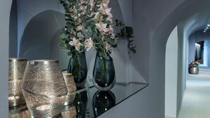 Une table en verre ornée de vases contenant des fleurs et de lampes décoratives.