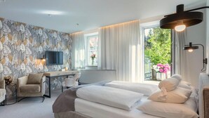 Une chambre moderne avec un grand lit, un bureau et un téléviseur.