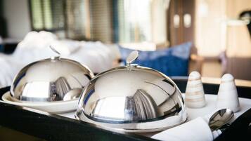 A tray with two covered dishes, a spoon, and a napkin.