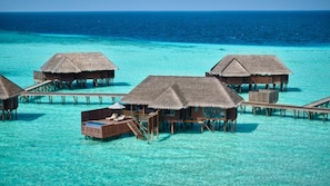 Overwater bungalows with thatched roofs, wooden walkways, and clear turquoise water. - Conrad Maldives Rangali Island (Rangalifinolhu)