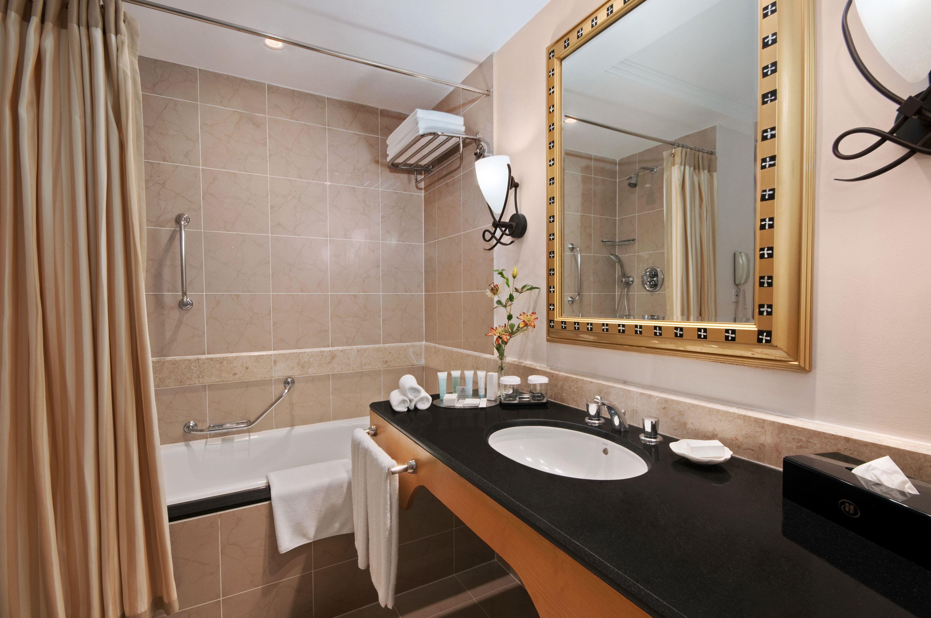 A modern bathroom with a bathtub, a sink, and a shower.