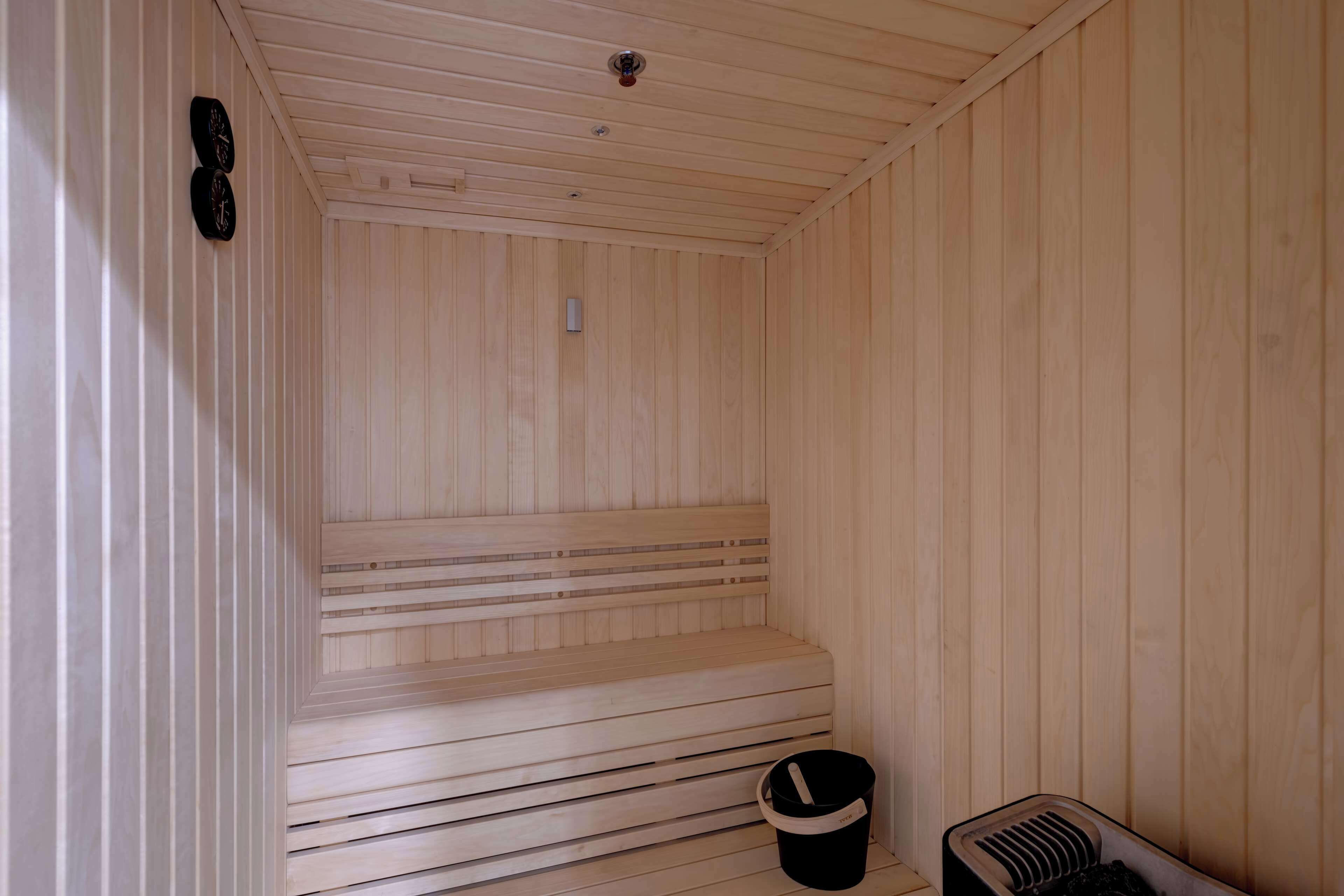 Una sauna de madera con bancos y un sistema de ventilación.