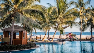 På stranden, vit sandstrand, parasoller och strandhanddukar