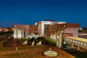 Experience the grand entrance of this hotel, featuring a large arched entrance and a beautiful fountain.