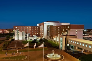 Experience the grand entrance of this hotel, featuring a large arched entrance and a beautiful fountain.