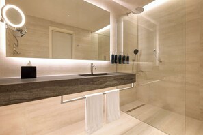 Features a sleek countertop with sink, handheld showerhead, and ample storage for toiletries.