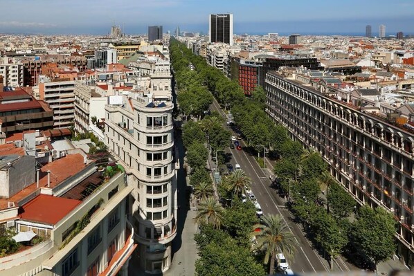 A cityscape with a prominent curved building on the left and a long row of buildings on the right. - Wilson Boutique Hotel (Barcelona)