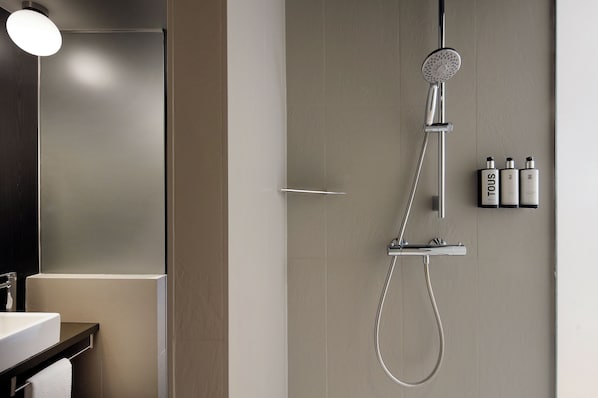 A modern bathroom with a shower, a sink, and a mirror. - Wilson Boutique Hotel (Barcelona)