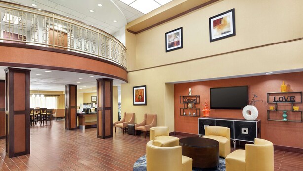A spacious lobby with a curved ceiling, comfortable seating, a TV, and a reception desk. - Hampton Inn Oklahoma City-I-40 E. (Tinker Air Force Base) (Midwest City)