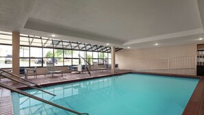 An indoor swimming pool with clear glass walls, a tiled floor, and a few lounge chairs and sunbeds. - Hampton Inn Oklahoma City-I-40 E. (Tinker Air Force Base) (Midwest City)