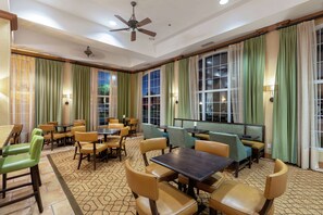 Enjoy meals in the dining area with a ceiling fan above and large windows.