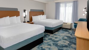 Une chambre d’hôtel avec deux lits, un bureau, une chaise, une lampe et une fenêtre avec des rideaux.