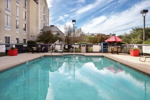 Relax by the rectangular pool surrounded by a secure fence and enjoy the shade under the umbrella.