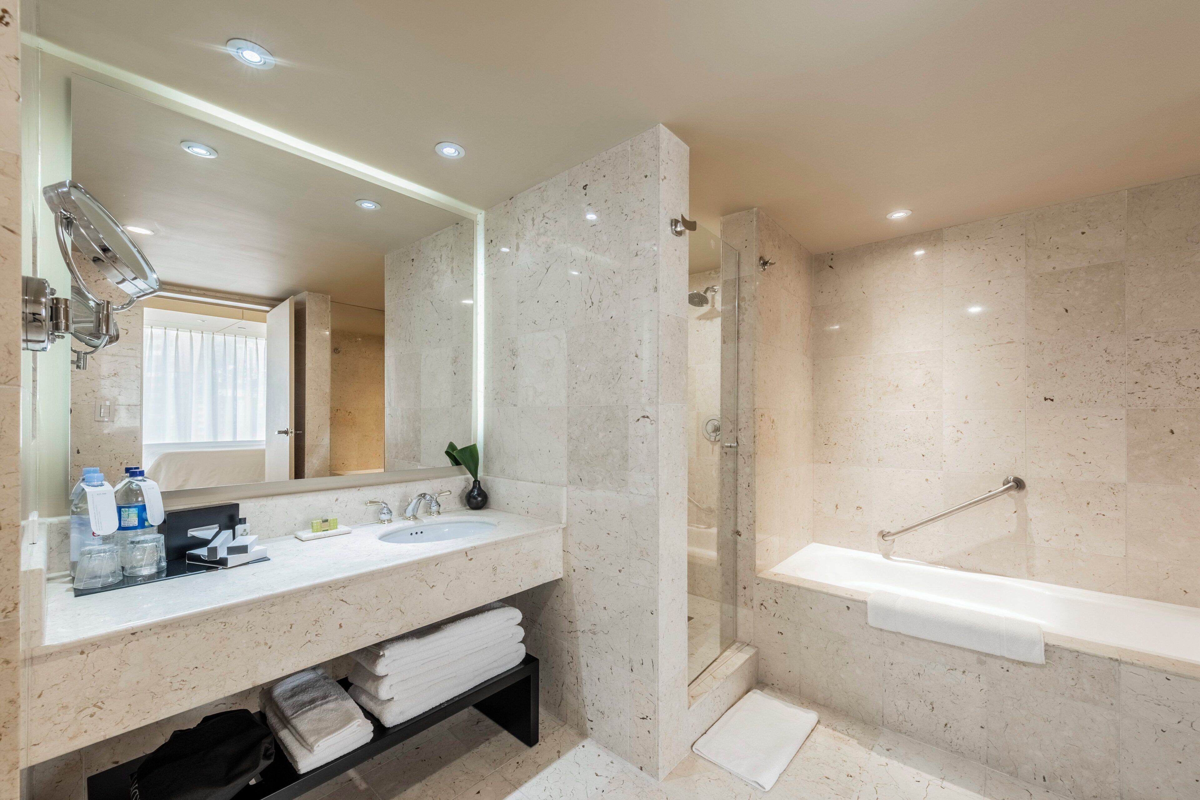Un baño moderno con un espejo grande, un lavabo, una ducha y una bañera.
