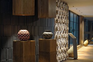 A modern interior with wooden panels, decorative vases, and a patterned wall.