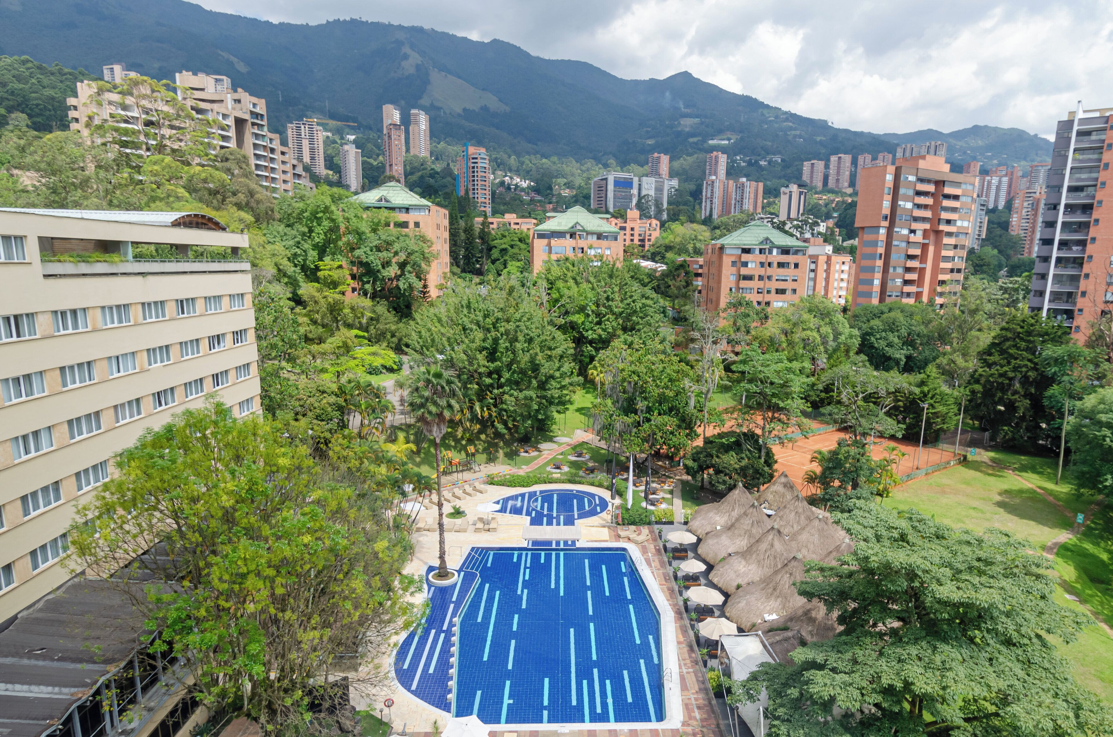A residential area with a swimming pool surrounded by trees and buildings.