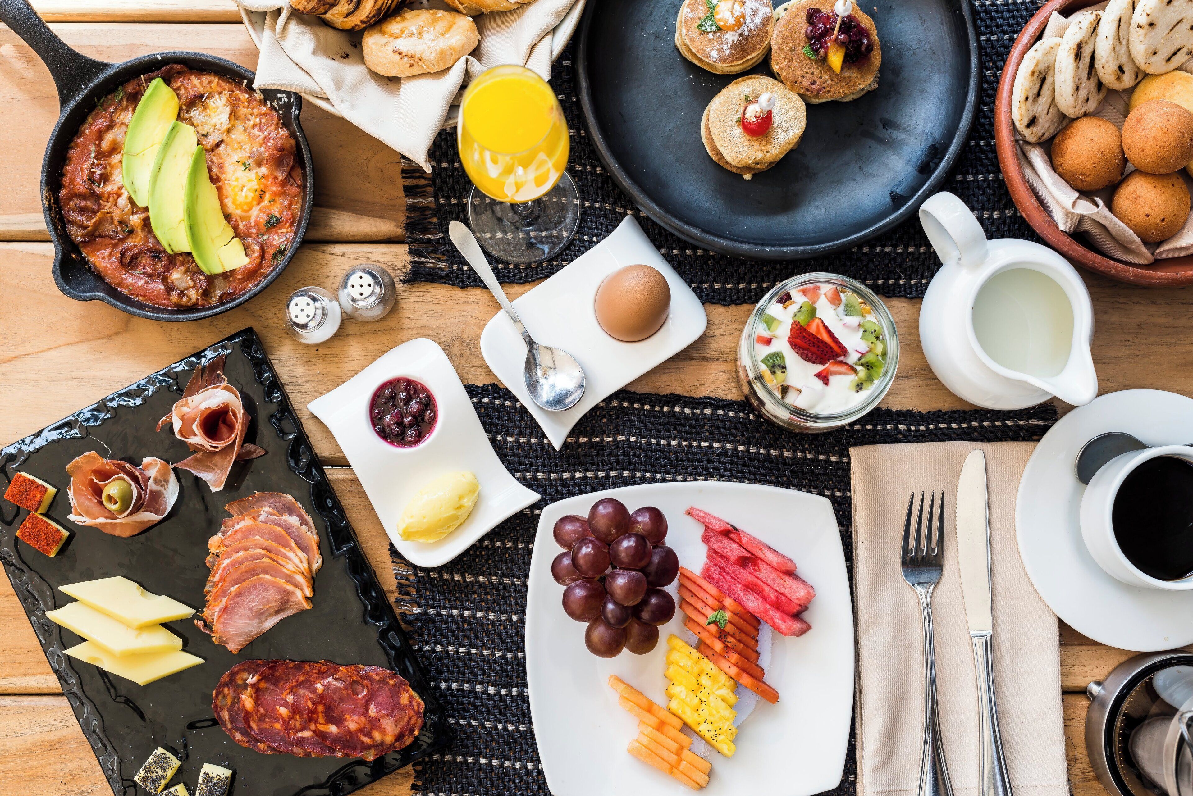 A breakfast spread with various foods and drinks on a table.