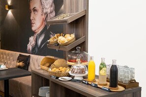 Ein reichhaltiges Frühstücksbuffet mit Brot, Gebäck und verschiedenen Getränken.