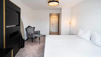 Una habitación de hotel con cama, una silla, un escritorio y un televisor.