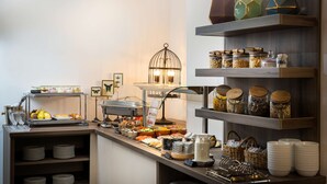 Un montaje tipo bufé con diferentes opciones de comida, bandejas de servicio y una estación de café.