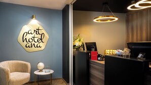 Un área de recepción de diseño moderno, con un mostrador de recepción, un globo terráqueo sobre una mesita y una silla.