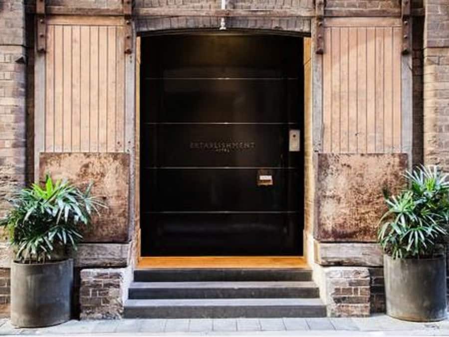 Entrada de un edificio con una puerta negra que dice "ESTABLISHMENT".