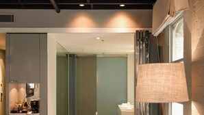 En modern inredning med en soffa, ett runt bord och en golvlampa.