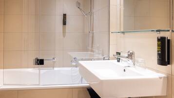 Ein modernes Badezimmer mit einer begehbaren Glasdusche, einem weißen Waschbecken und einem Glasregal.