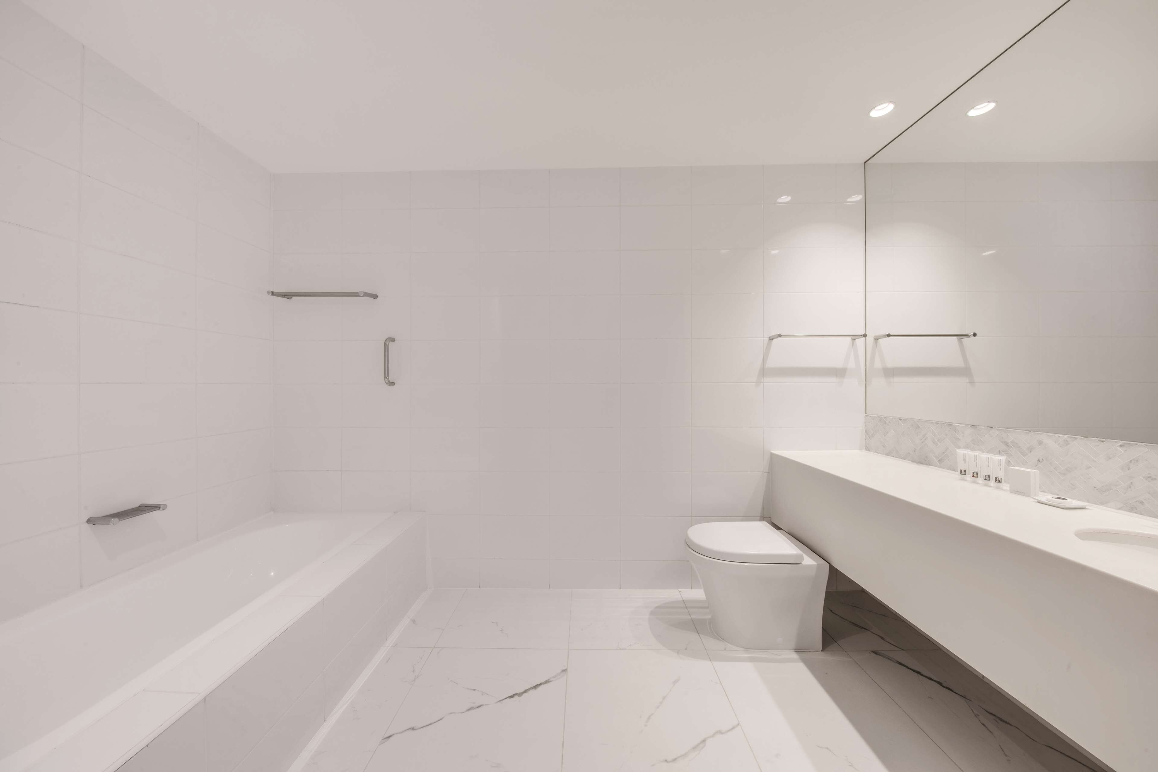 Een moderne badkamer met bad, toilet en wastafel.