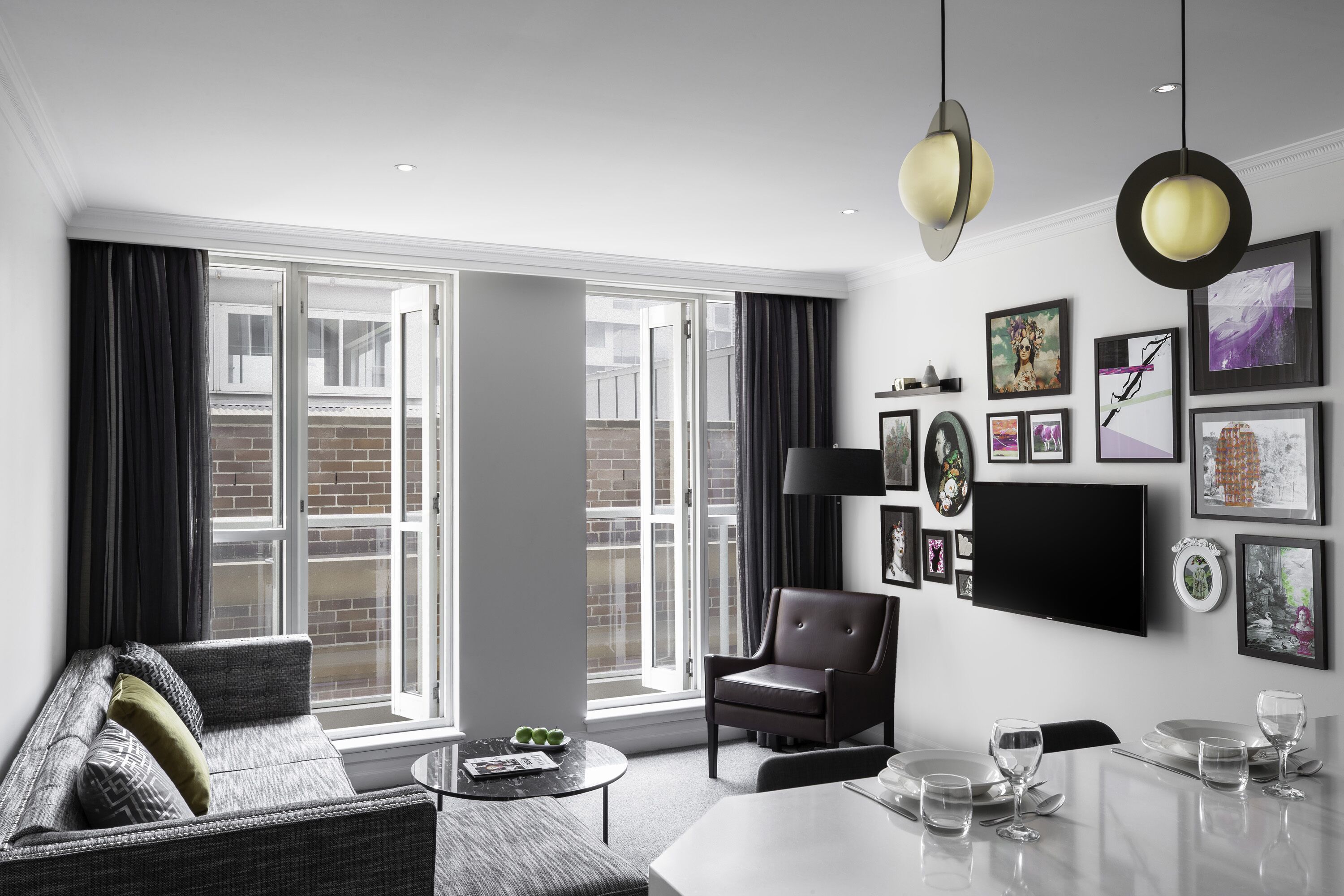 Un salon moderne avec un canapé, un fauteuil et une table à manger pour six personnes.