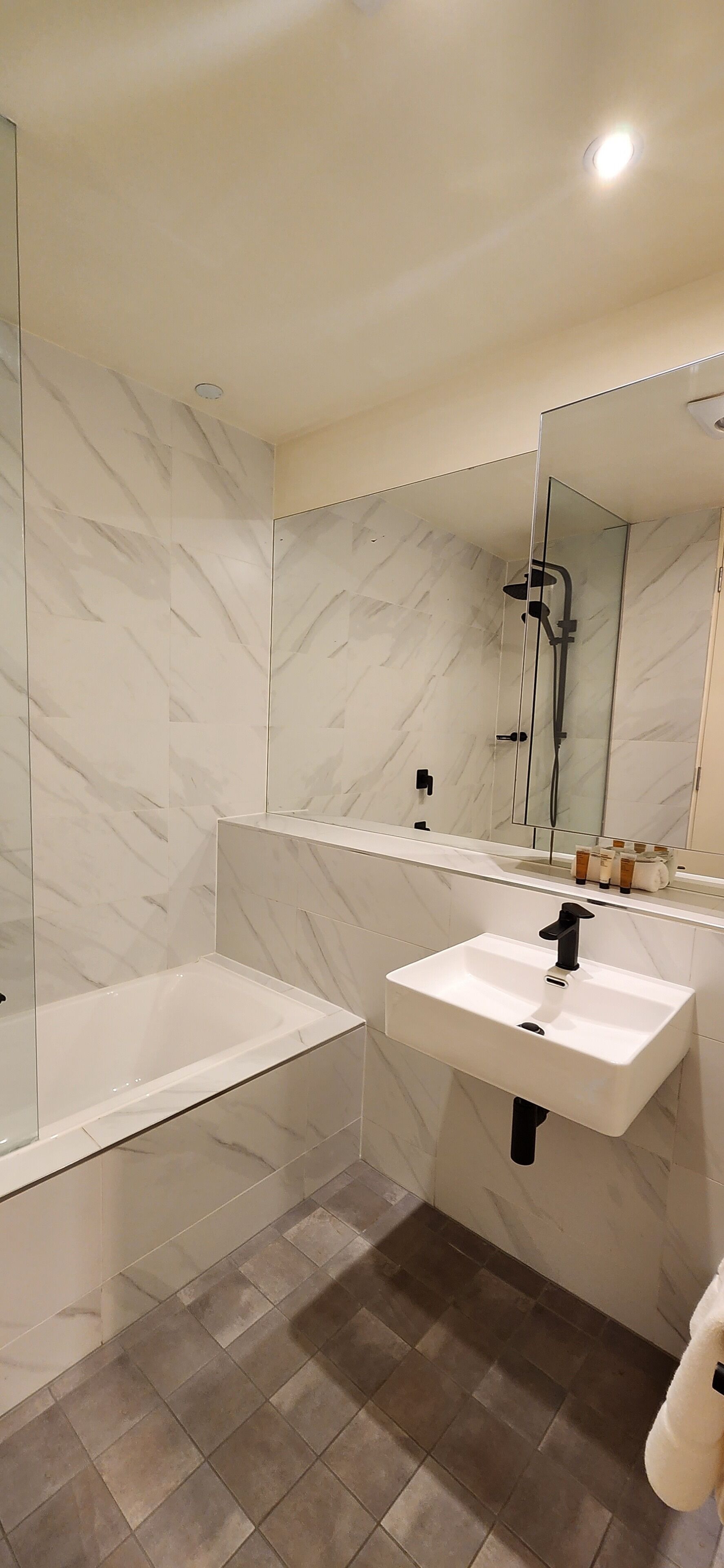 Een moderne badkamer met een bad, een wastafel en een douche.