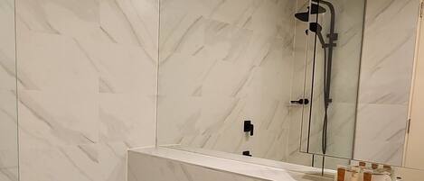 Een moderne badkamer met een bad, een wastafel en een douche.