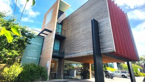 A modern building with a unique architectural design, featuring a combination of wooden panels and glass. - Phillip Island Apartments (Cowes)