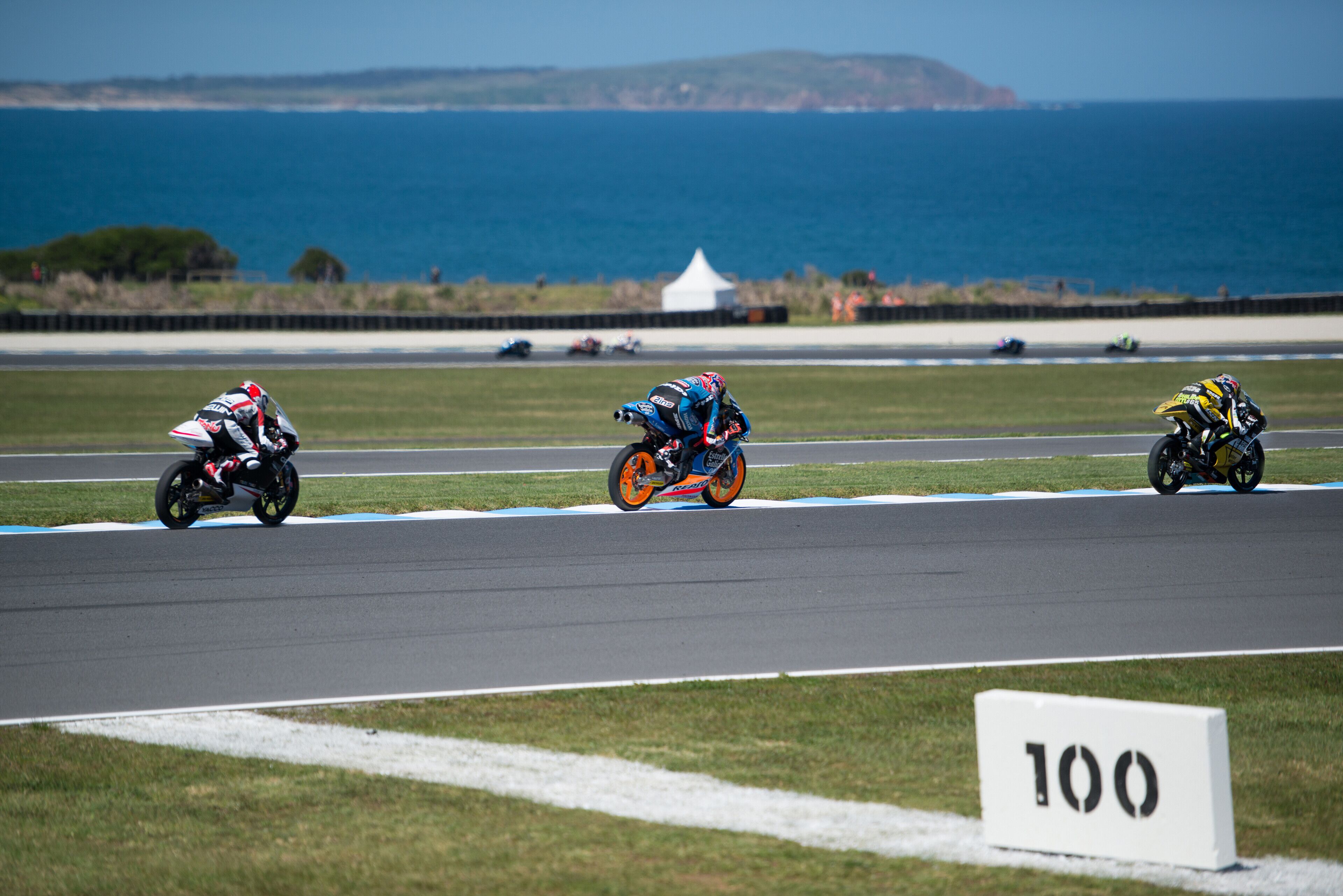 A race track with three motorcyclists.