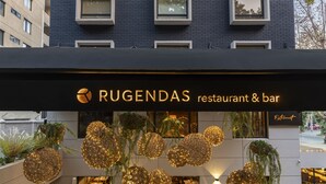 Das äußere Erscheinungsbild des Restaurants und der Bar Rugendas mit hängenden, kugelförmigen Lampen und Pflanzen.