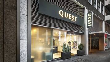 A modern building with a large glass entrance and the name "QUEST" prominently displayed above.