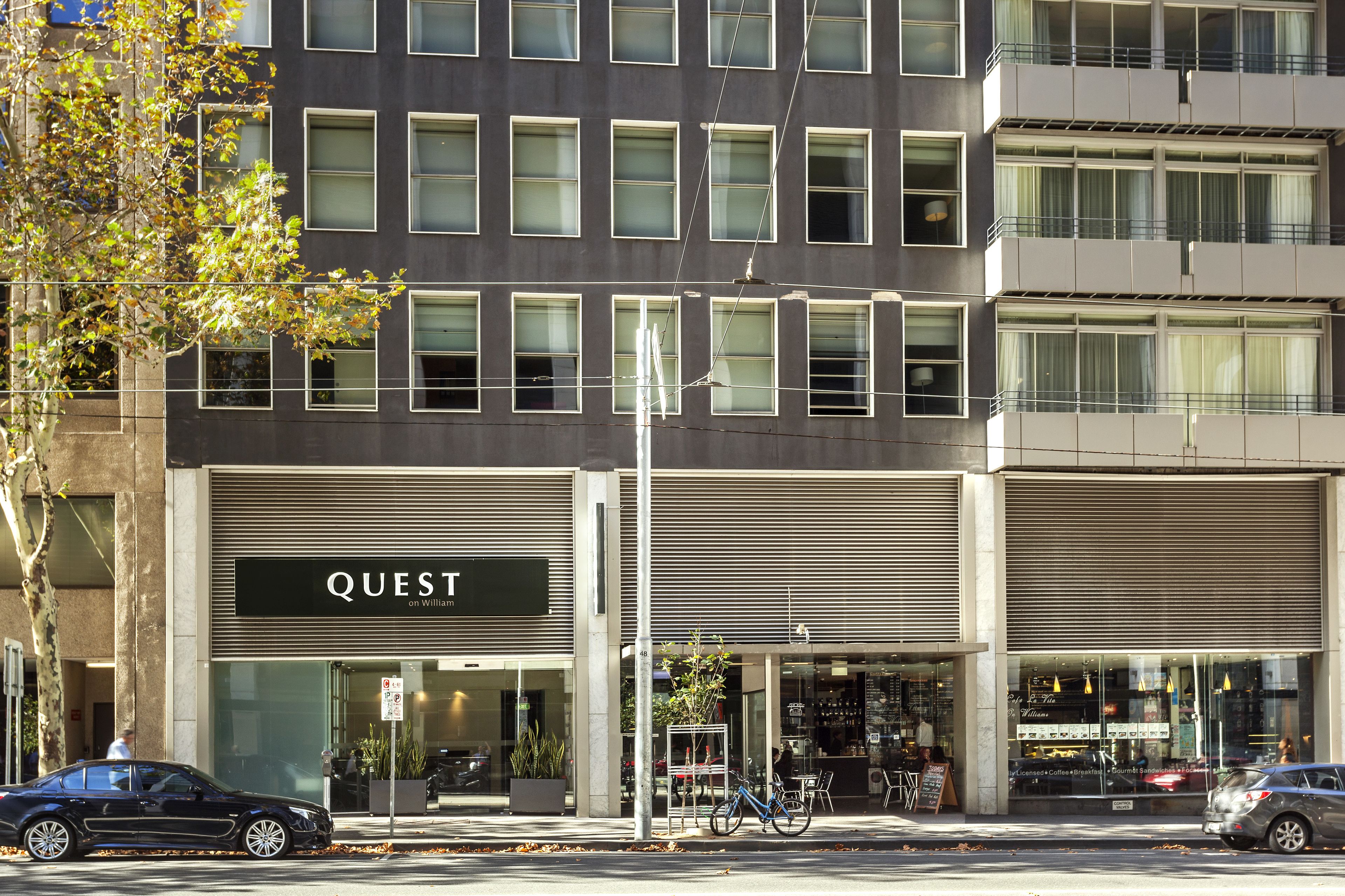 A modern building with a storefront labeled "QUEST" and a visible entrance.