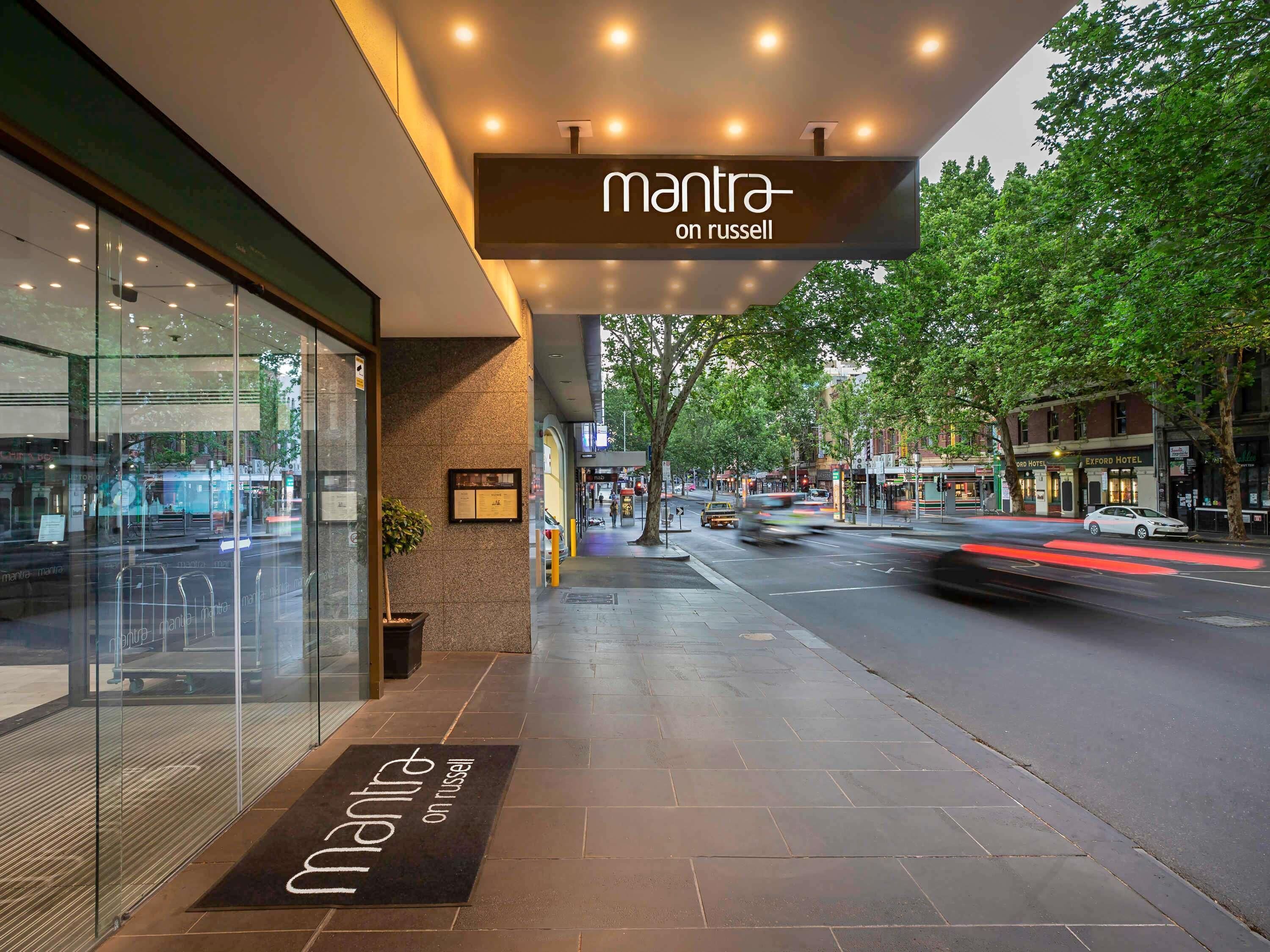 Un edificio moderno con un'insegna che recita 'mantra on russell' e un tappetino d'ingresso con lo stesso nome.
