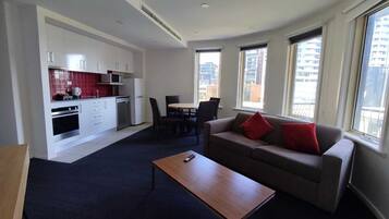 A modern apartment with a kitchen, dining area, and living room.
