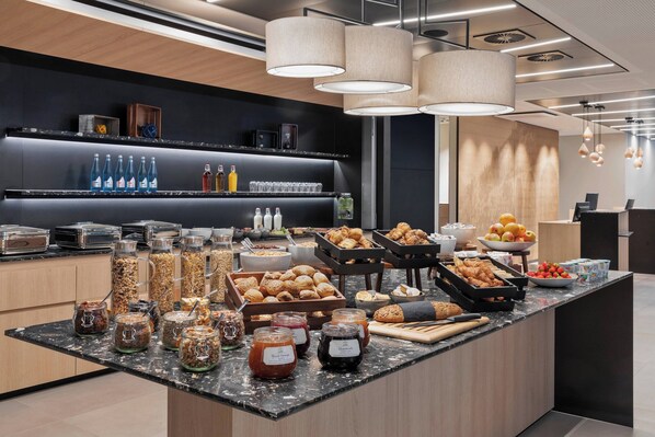 A buffet area with various food items and condiments. - Courtyard by Marriott Freiburg (Freiburg im Breisgau)
