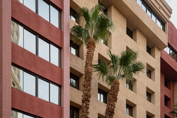 A multi-story building with a beige facade and red accents. - The Carriage House (Las Vegas)